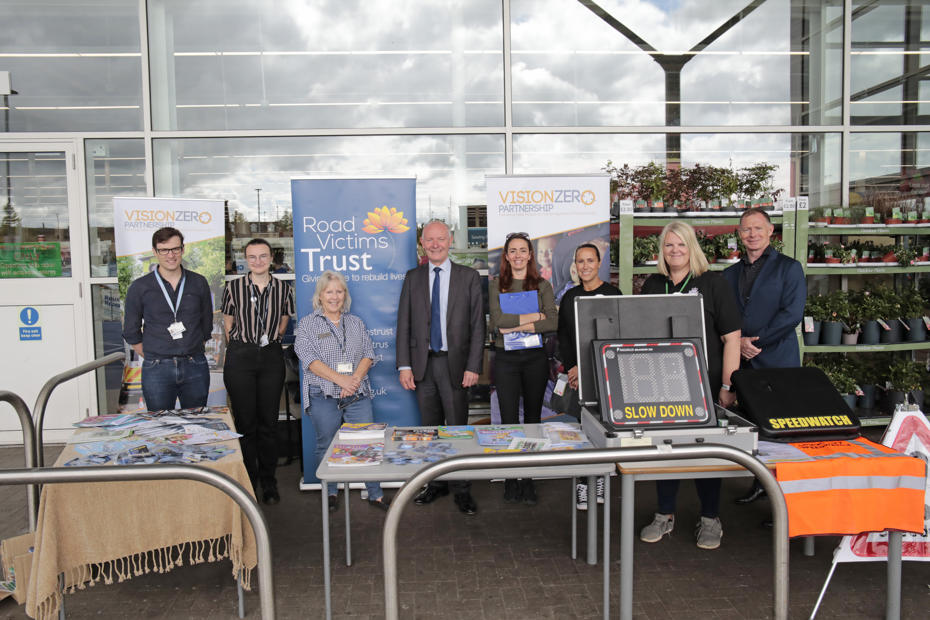 Image of the officers and staff from the Vision Zero Partnership, Road Victims Trust, the In Car Safety Centre, Speedwatch and Police and Crime Commissioner standing behind information stalls in Cambridge City